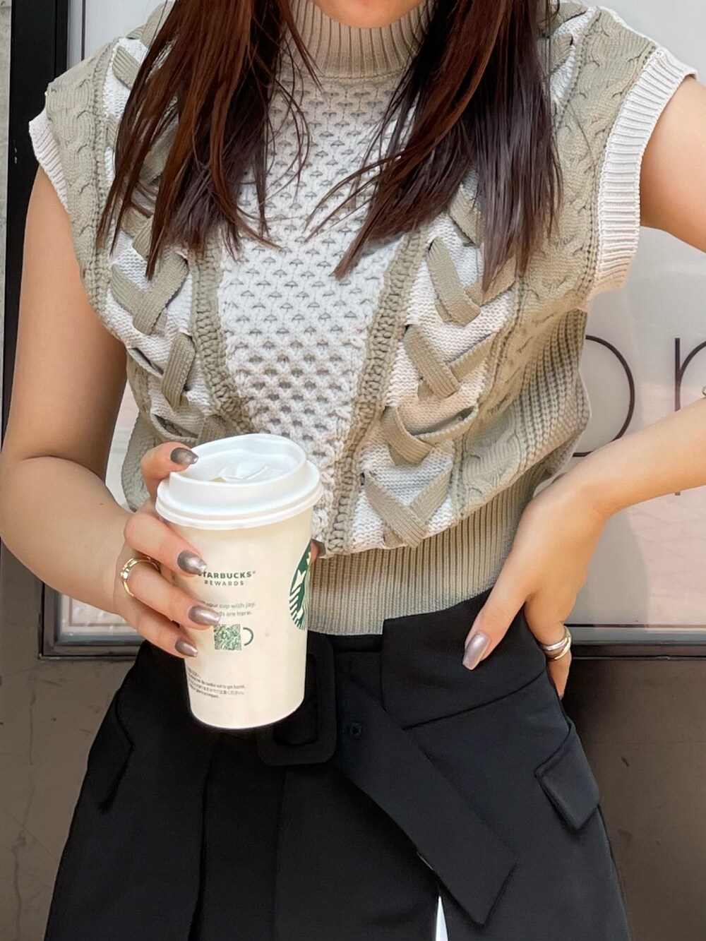 ブラック系のスラックス、ホワイト系のニット/セーター、ブラック系のブーツを着用したレディースの夏コーディネートの5枚目の写真