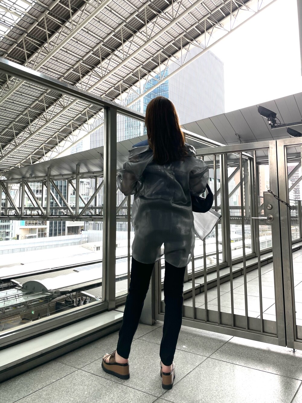 グレー系のシャツ/ブラウス、ブルー系のタンクトップ、ブラック系のハンドバッグを着用したレディースの春コーディネートの4枚目の写真