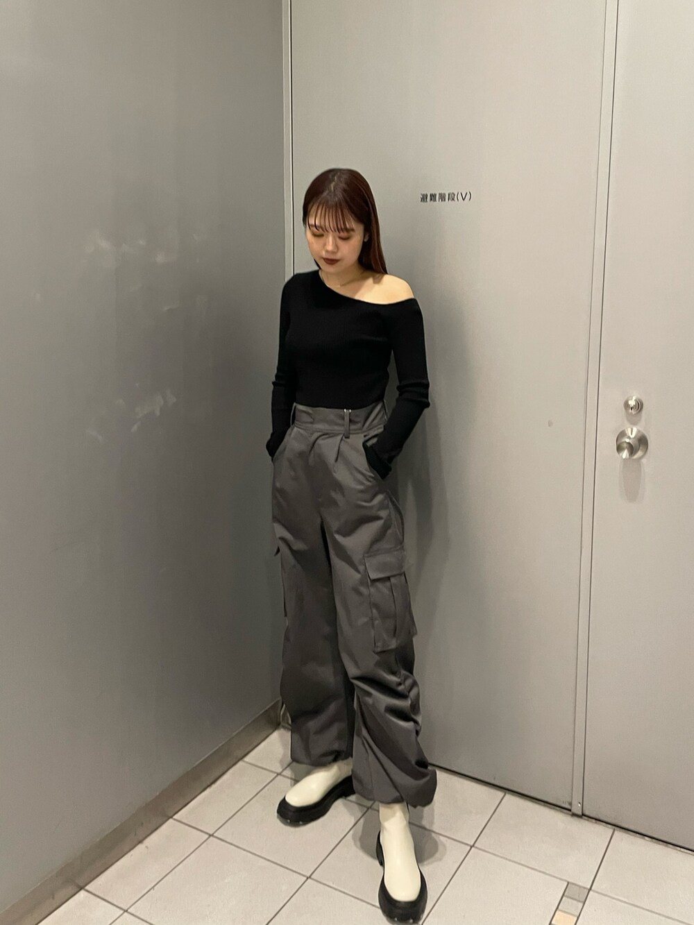 ブラック系のニット/セーター、グレー系のカーゴパンツ、ホワイト系のブーツを着用したレディースの冬コーディネートの2枚目の写真