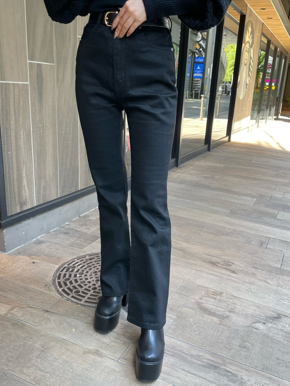 ブラック系のデニムパンツ、ブラック系のカーディガン/ボレロ、ブラック系のブーツを着用したレディースの秋コーディネートの7枚目の写真