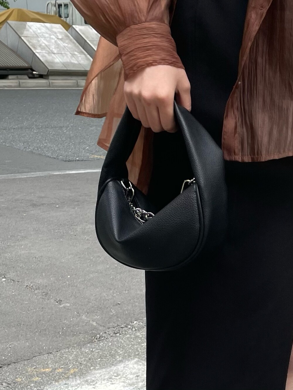 ブラック系のハンドバッグ、ブラック系のサンダル、ブラウン系のシャツ/ブラウスを着用したレディースの春コーディネートの7枚目の写真