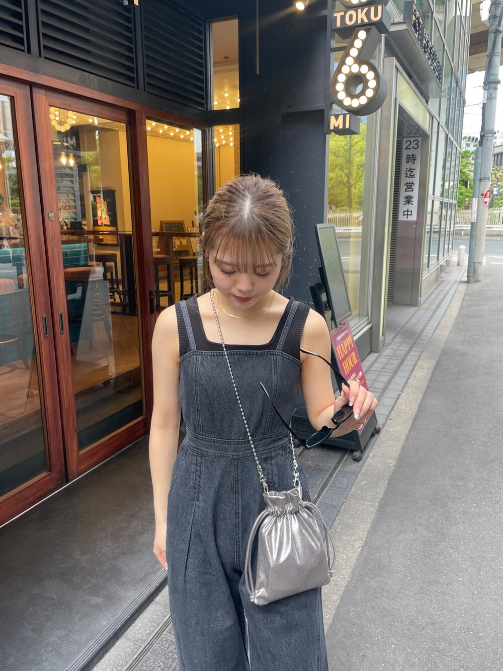 グレー系のショルダーバッグ、ブラック系のブーツ、ブラック系のニット/セーターを着用したレディースの春コーディネートの6枚目の写真