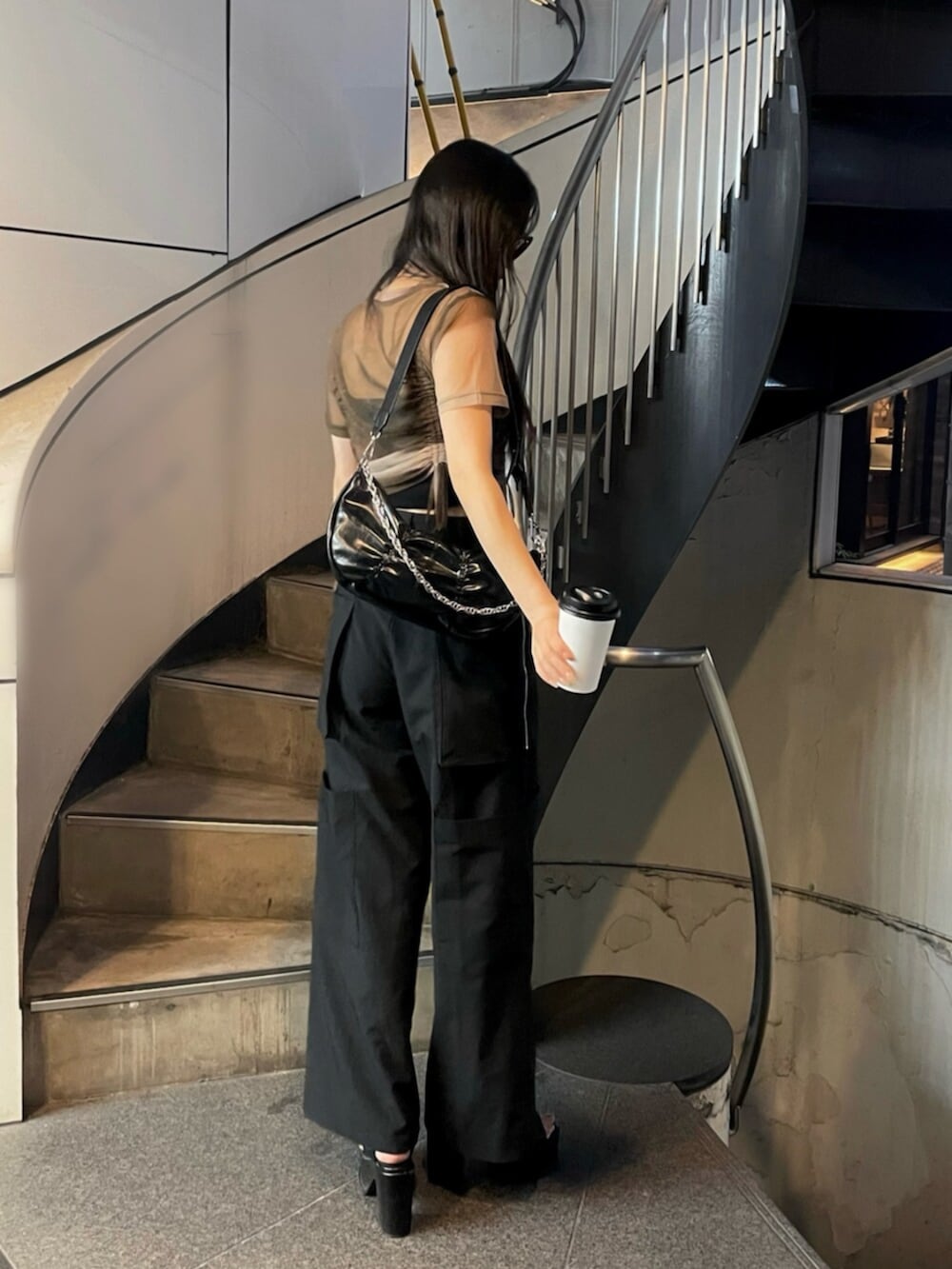 ブラック系のサンダル、ブラック系のキャミソール、ブラック系のスラックスを着用したレディースの春コーディネートの2枚目の写真