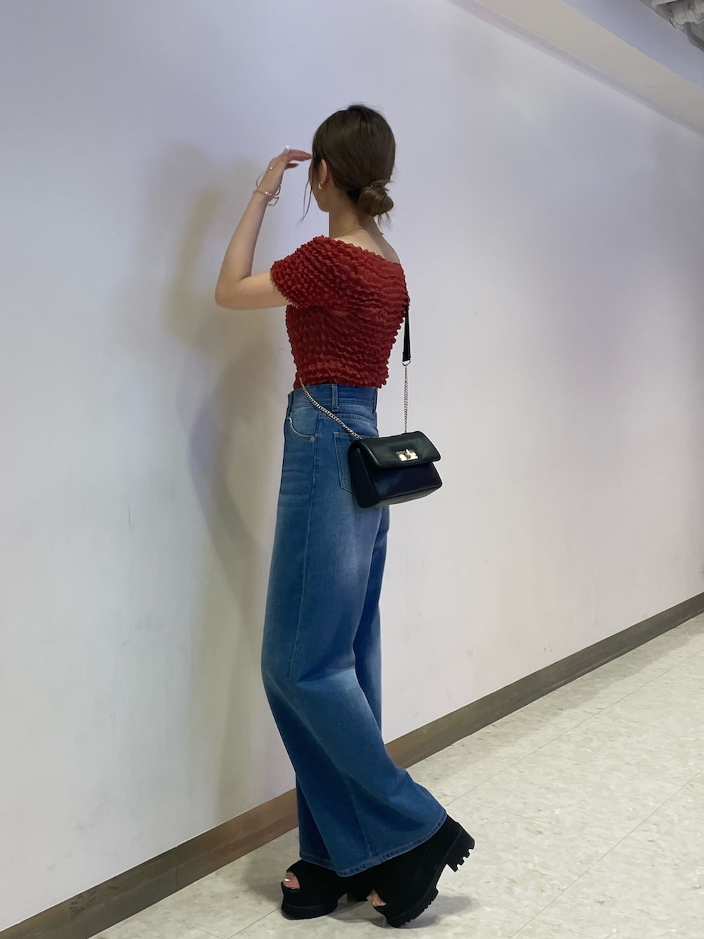 ブルー系のデニムパンツ、ブラック系のブーツ、レッド系のシャツ/ブラウスを着用したレディースの春コーディネートの2枚目の写真