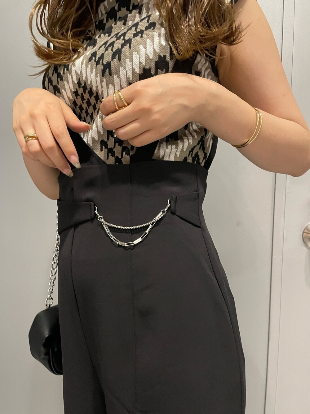 ブラウン系のニット/セーター、ブラック系のスラックス、ブラック系のハンドバッグを着用したレディースの夏コーディネートの7枚目の写真