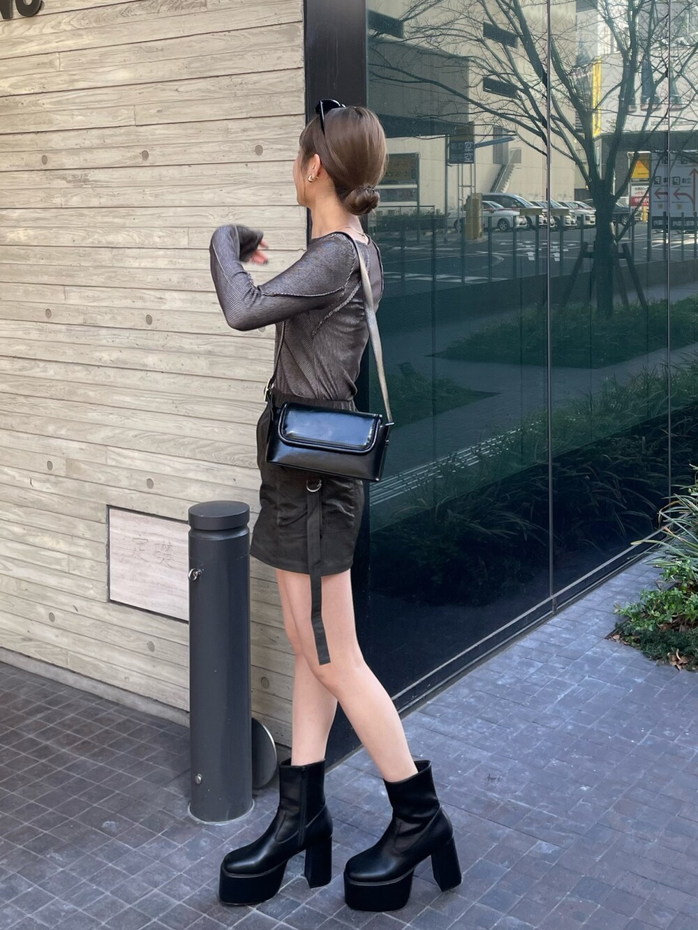 ブラック系のショルダーバッグ、グレー系のTシャツ/カットソー、ベージュ系のスカートを着用したレディースの冬コーディネートの3枚目の写真