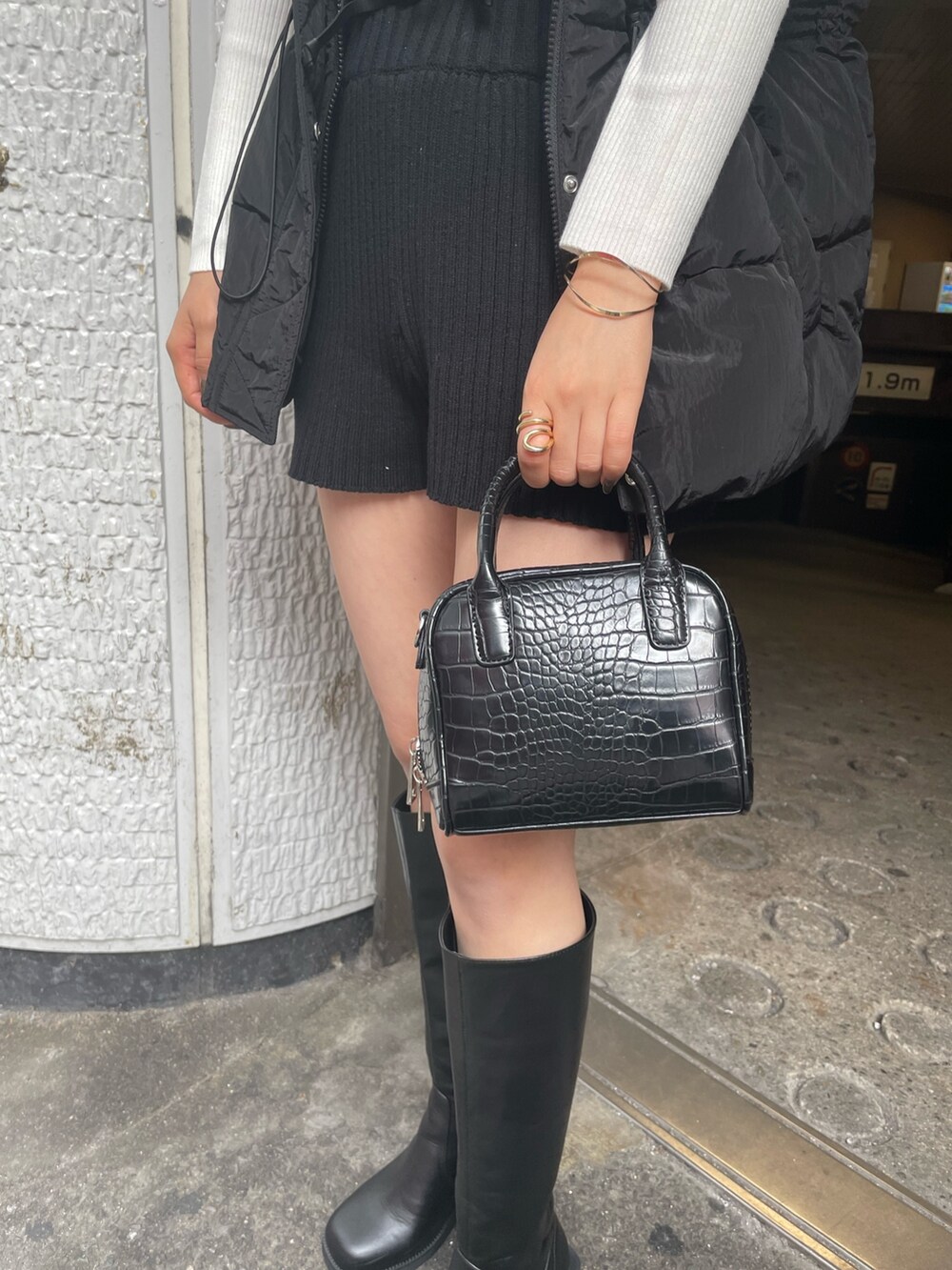 ブラック系のダウンベスト、ホワイト系のニット/セーター、ブラック系のその他パンツを着用したレディースの秋コーディネートの6枚目の写真