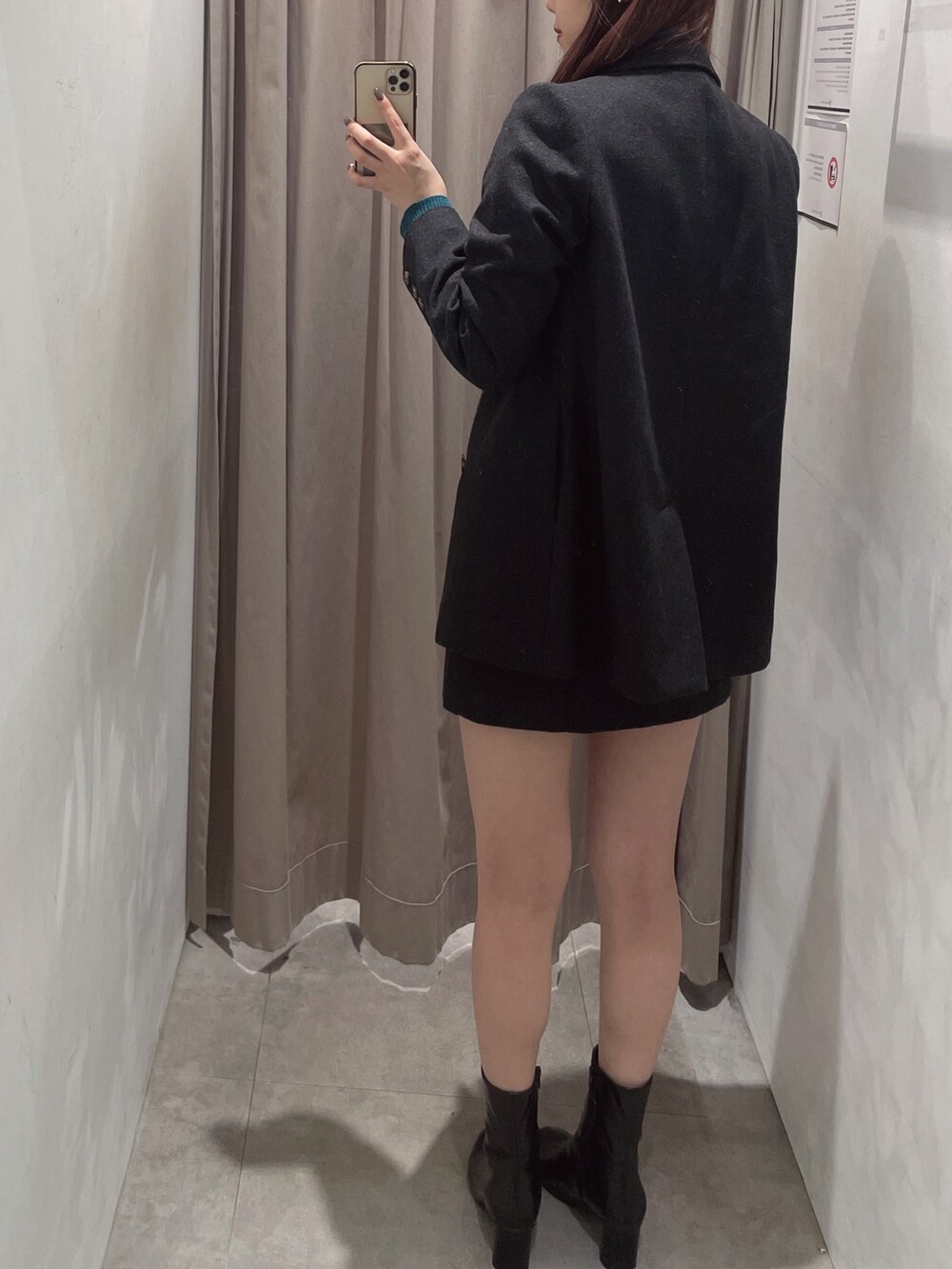 グレー系のスカート、ブラック系のブーツ、グレー系のテーラードジャケットを着用したレディースの秋コーディネートの3枚目の写真