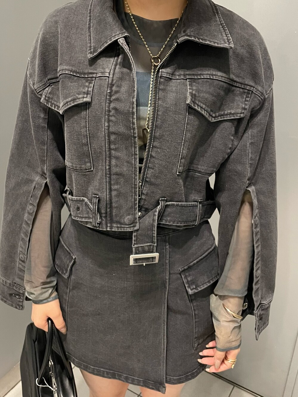 ブラック系のブーツ、ブラック系のスカート、その他のTシャツ/カットソーを着用したレディースの夏コーディネートの6枚目の写真