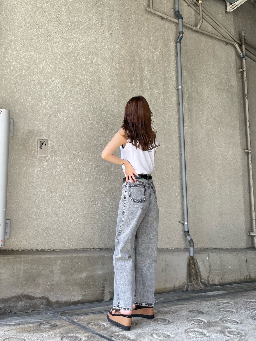 ホワイト系のタンクトップ、シルバー系のハンドバッグ、ブラック系のサンダルを着用したレディースの春コーディネートの3枚目の写真