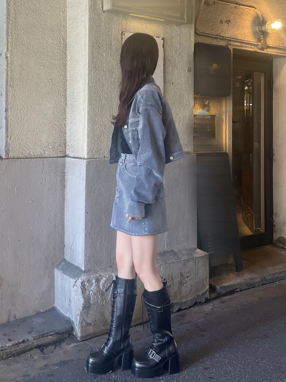 グレー系のスカート、ブラック系のブーツ、ブラック系のTシャツ/カットソーを着用したレディースの夏コーディネートの2枚目の写真