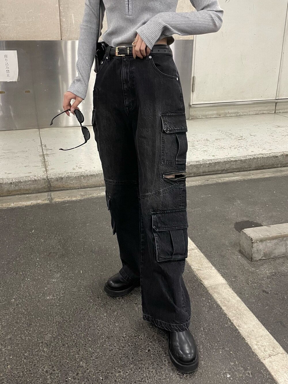 ブラック系のデニムパンツ、ブラック系のショルダーバッグ、グレー系のTシャツ/カットソーを着用したレディースの冬コーディネートの7枚目の写真