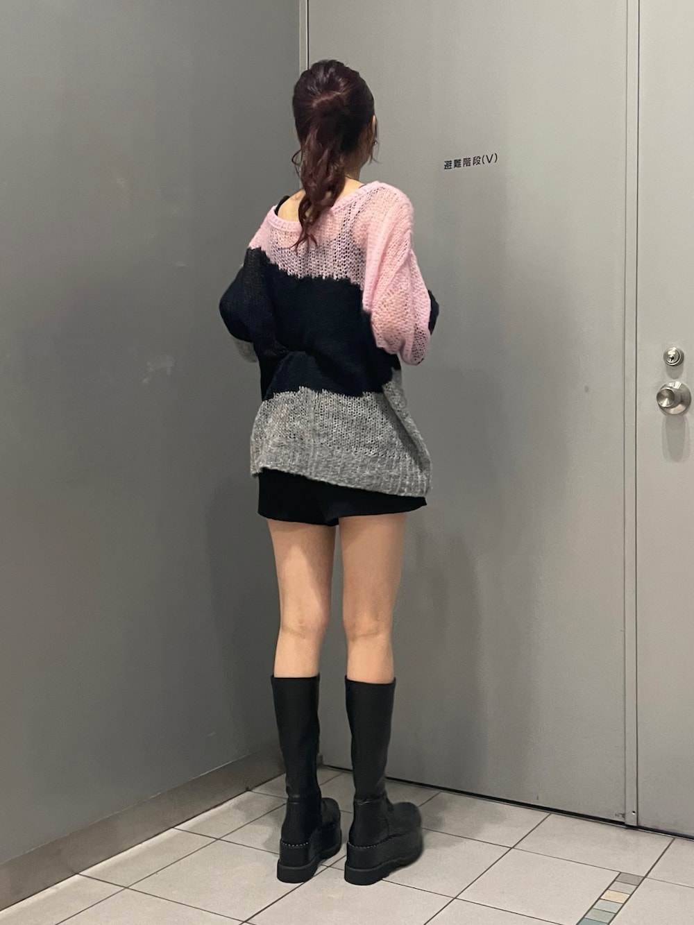 ブラック系のブーツ、ブラック系のその他パンツ、ブルー系のニット/セーターを着用したレディースの秋コーディネートの3枚目の写真