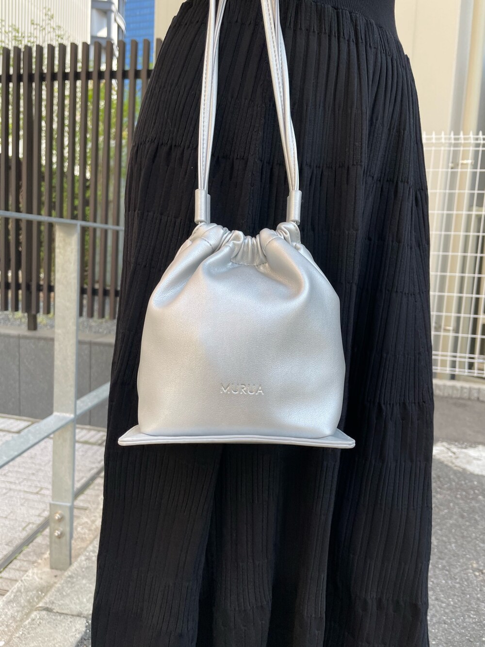 ブラック系のワンピース、シルバー系のハンドバッグ、その他のサンダルを着用したレディースの春コーディネートの8枚目の写真