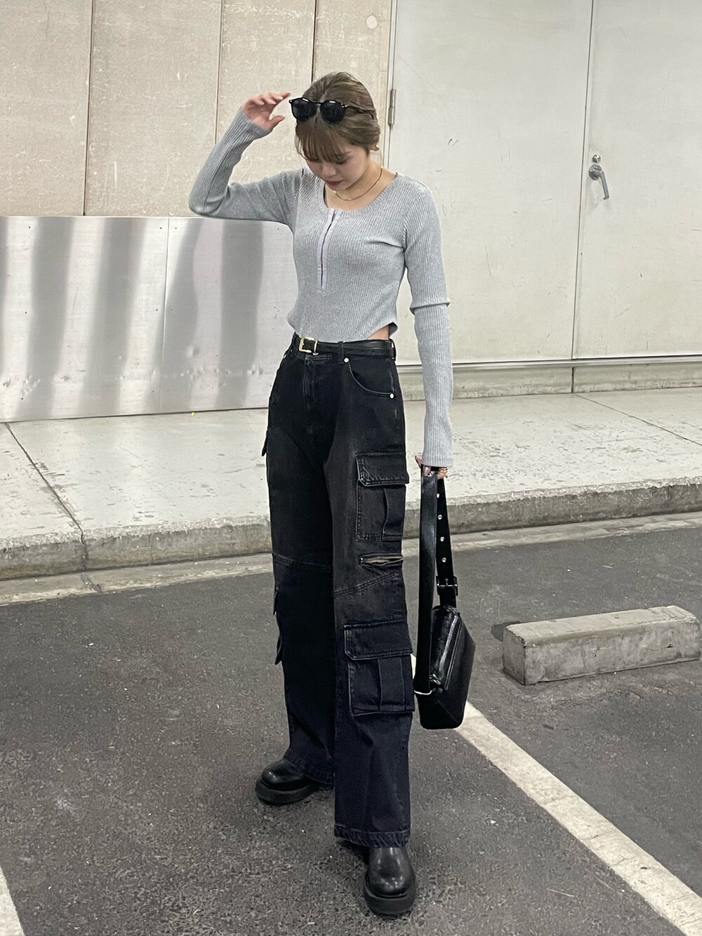 ブラック系のデニムパンツ、ブラック系のショルダーバッグ、グレー系のTシャツ/カットソーを着用したレディースの冬コーディネートの2枚目の写真