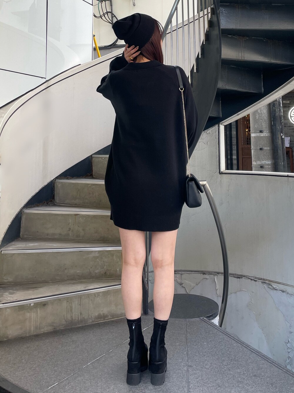 ブラック系のワンピース、ブラック系のブーツを着用したレディースの冬コーディネートの3枚目の写真