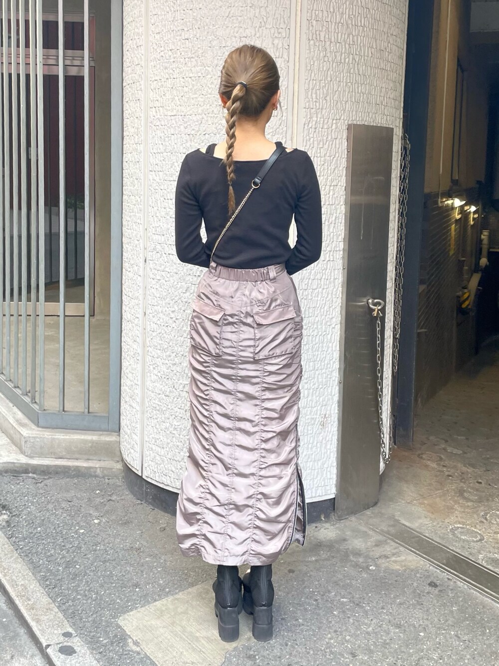 ブラック系のブーツ、グレー系のスカート、ブラック系のTシャツ/カットソーを着用したレディースの春コーディネートの3枚目の写真