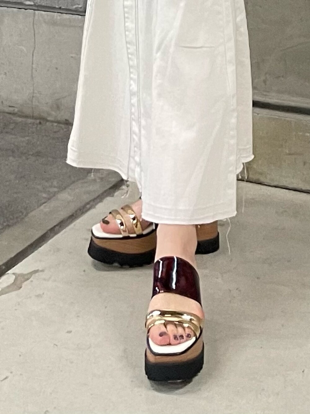 ブラック系のニット/セーター、ホワイト系のデニムスカート、ホワイト系のハンドバッグを着用したレディースの春コーディネートの8枚目の写真