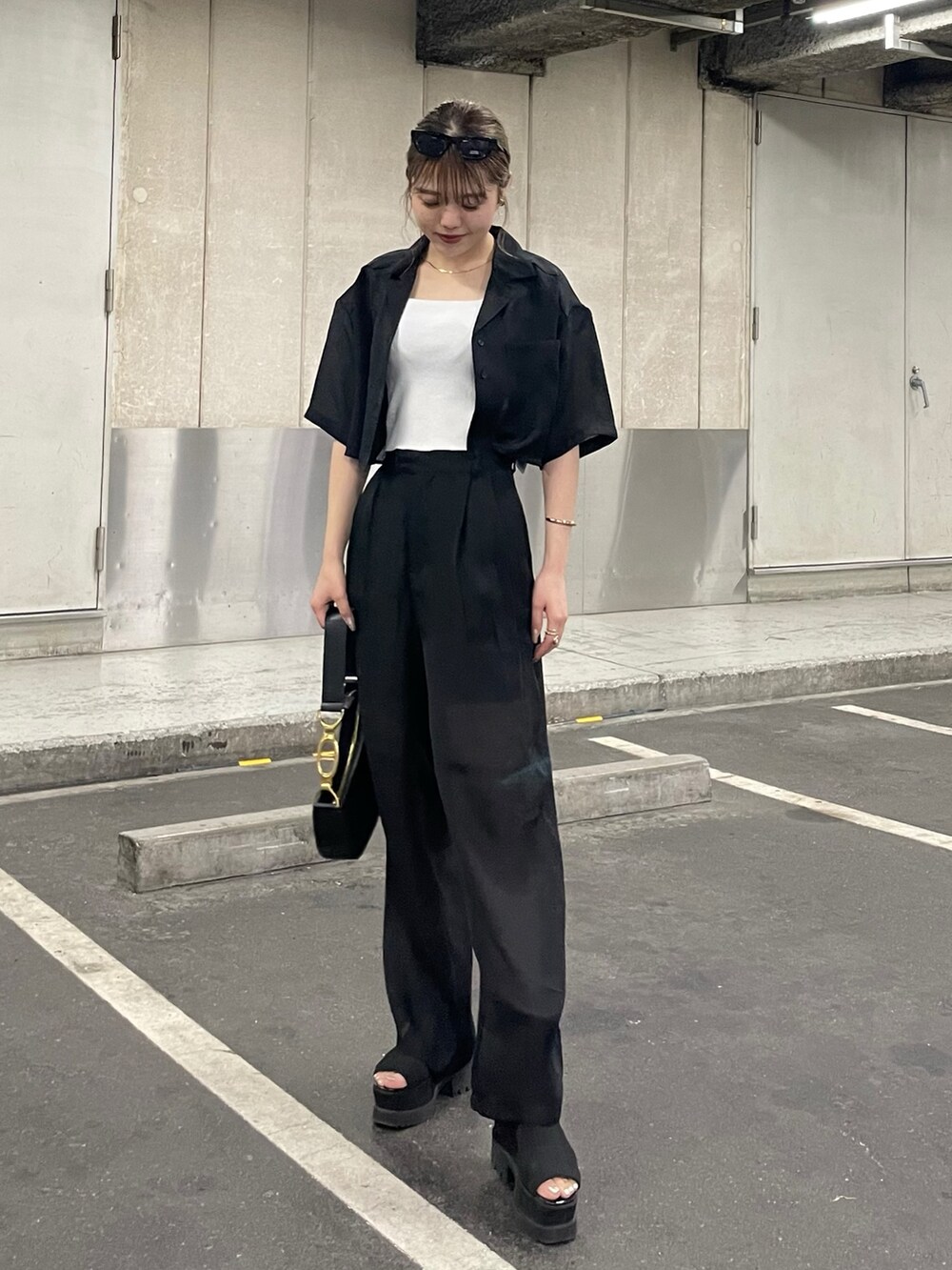 ブラック系のブーツ、ブラック系のその他パンツ、ホワイト系のニット/セーターを着用したレディースの夏コーディネートの2枚目の写真