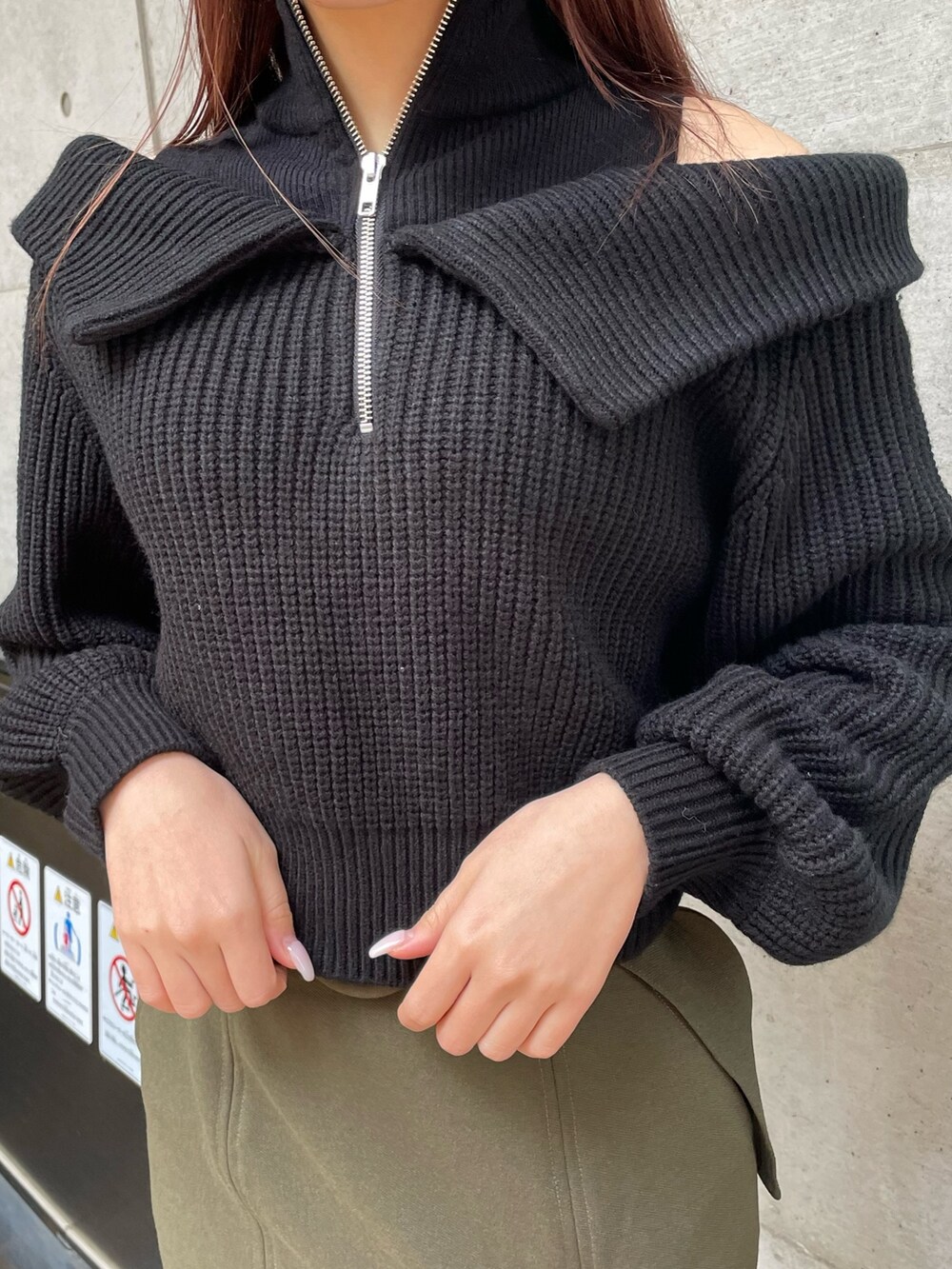 ブラック系のブーツ、グリーン系のスカート、ブラック系のニット/セーターを着用したレディースの冬コーディネートの6枚目の写真