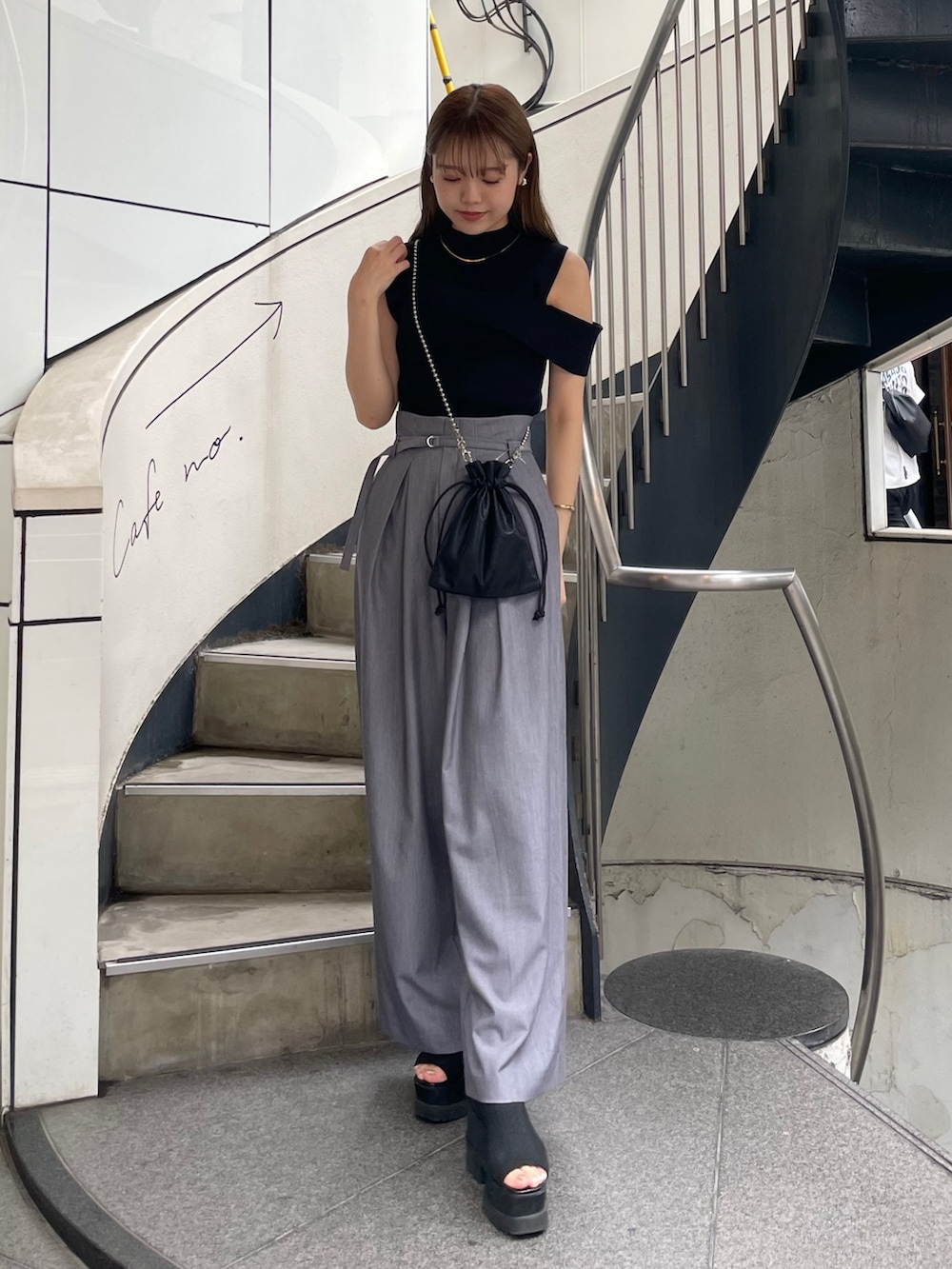 ブラック系のニット/セーター、ブラック系のショルダーバッグ、グレー系のその他パンツを着用したレディースの春コーディネートの2枚目の写真