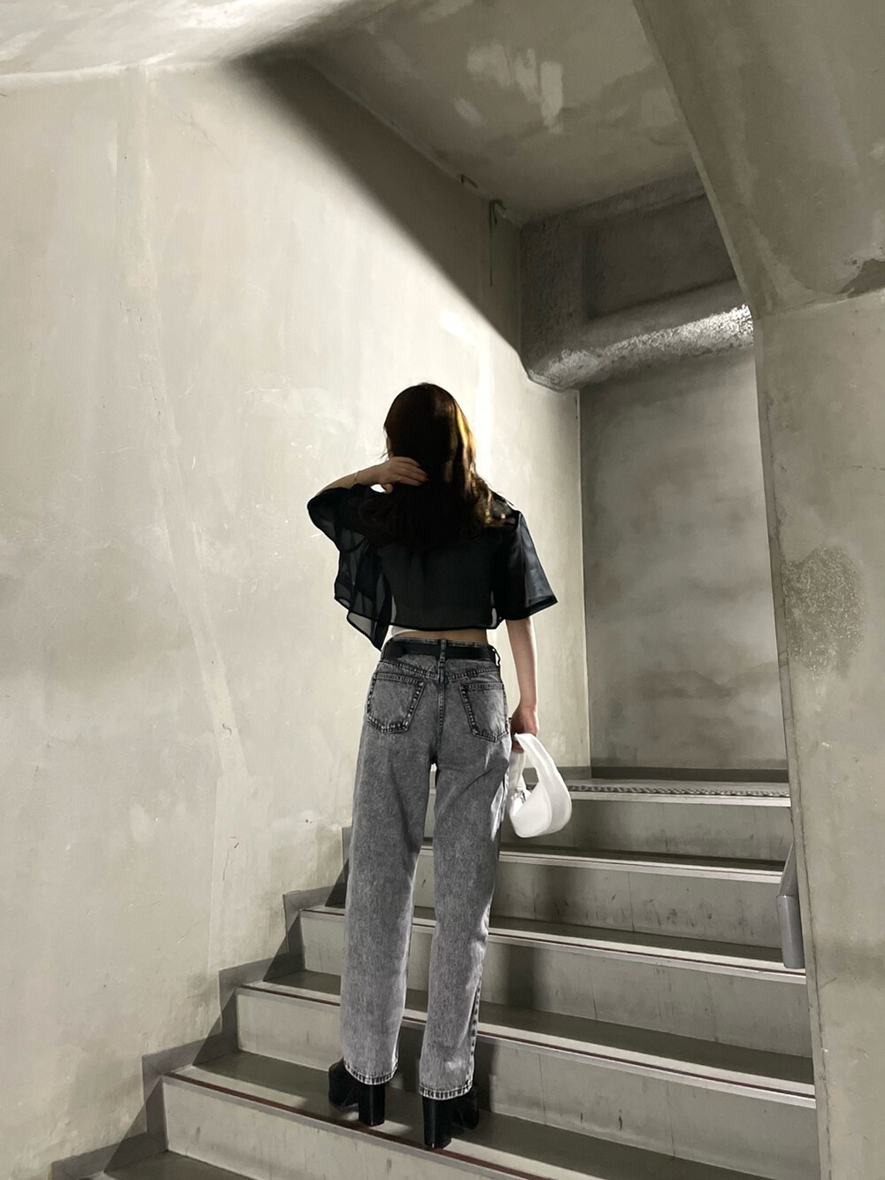 ホワイト系のTシャツ/カットソー、グレー系のデニムパンツ、ブラック系のサンダルを着用したレディースの春コーディネートの4枚目の写真