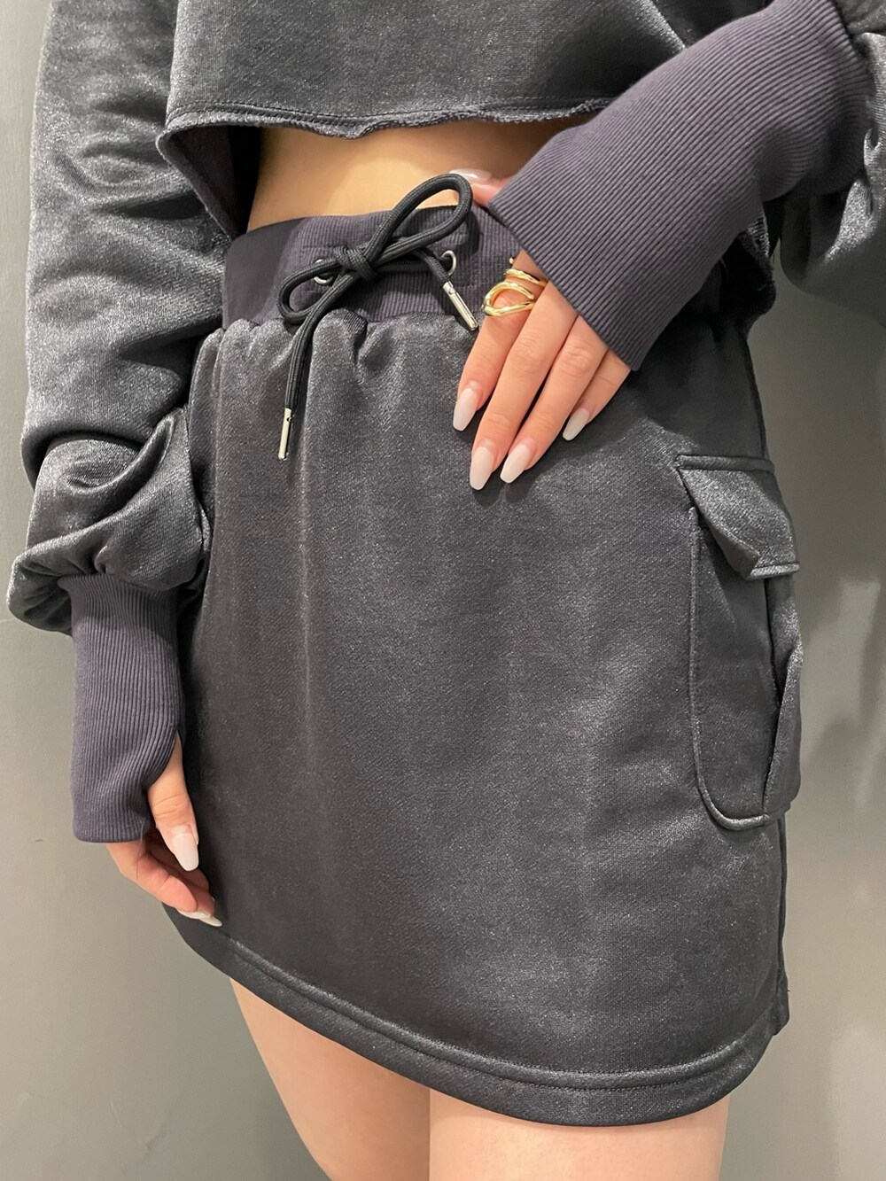 ブラック系のブーツ、グレー系のスカート、グレー系のTシャツ/カットソーを着用したレディースの冬コーディネートの6枚目の写真