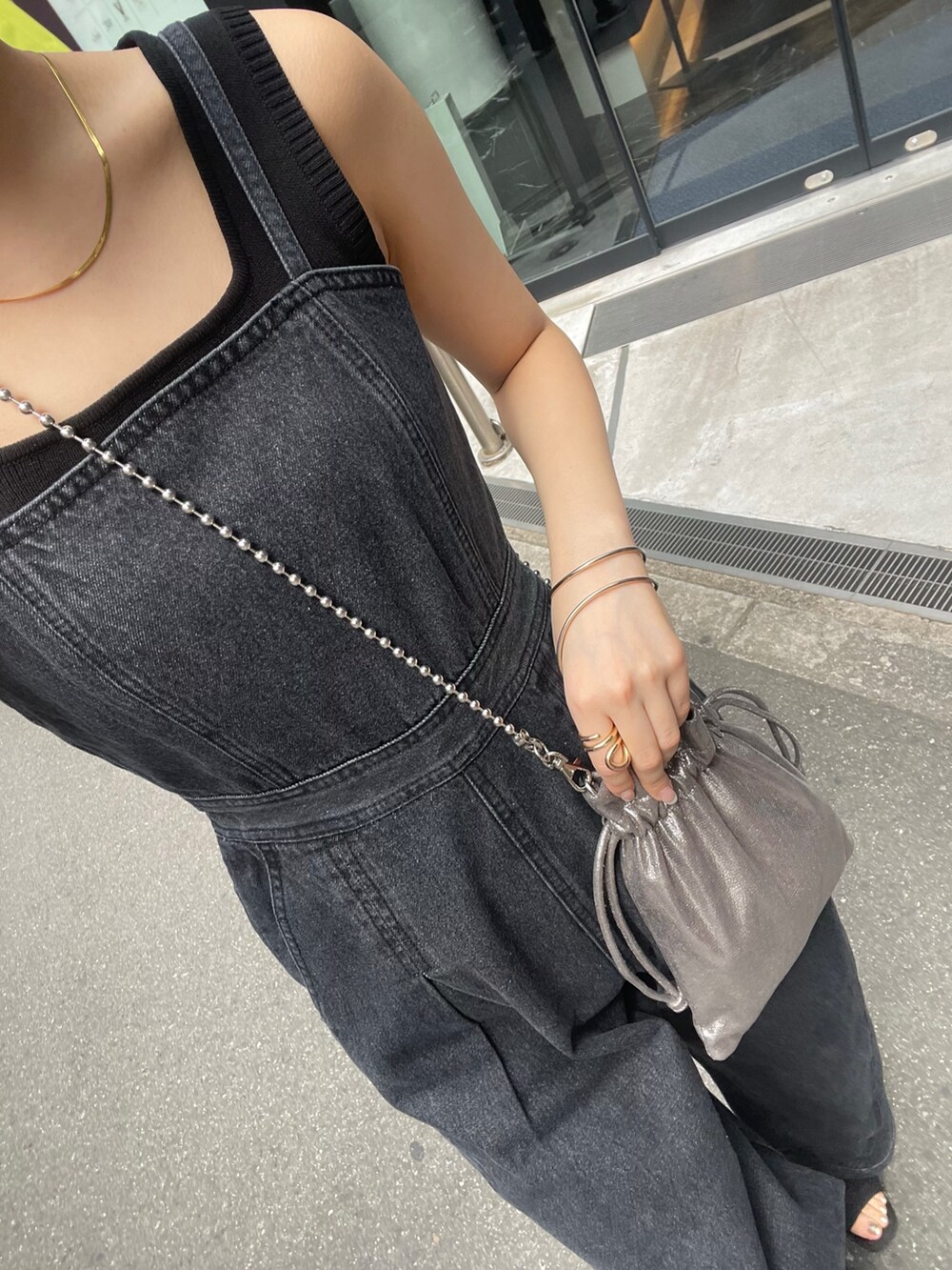 グレー系のショルダーバッグ、ブラック系のブーツ、ブラック系のニット/セーターを着用したレディースの春コーディネートの8枚目の写真