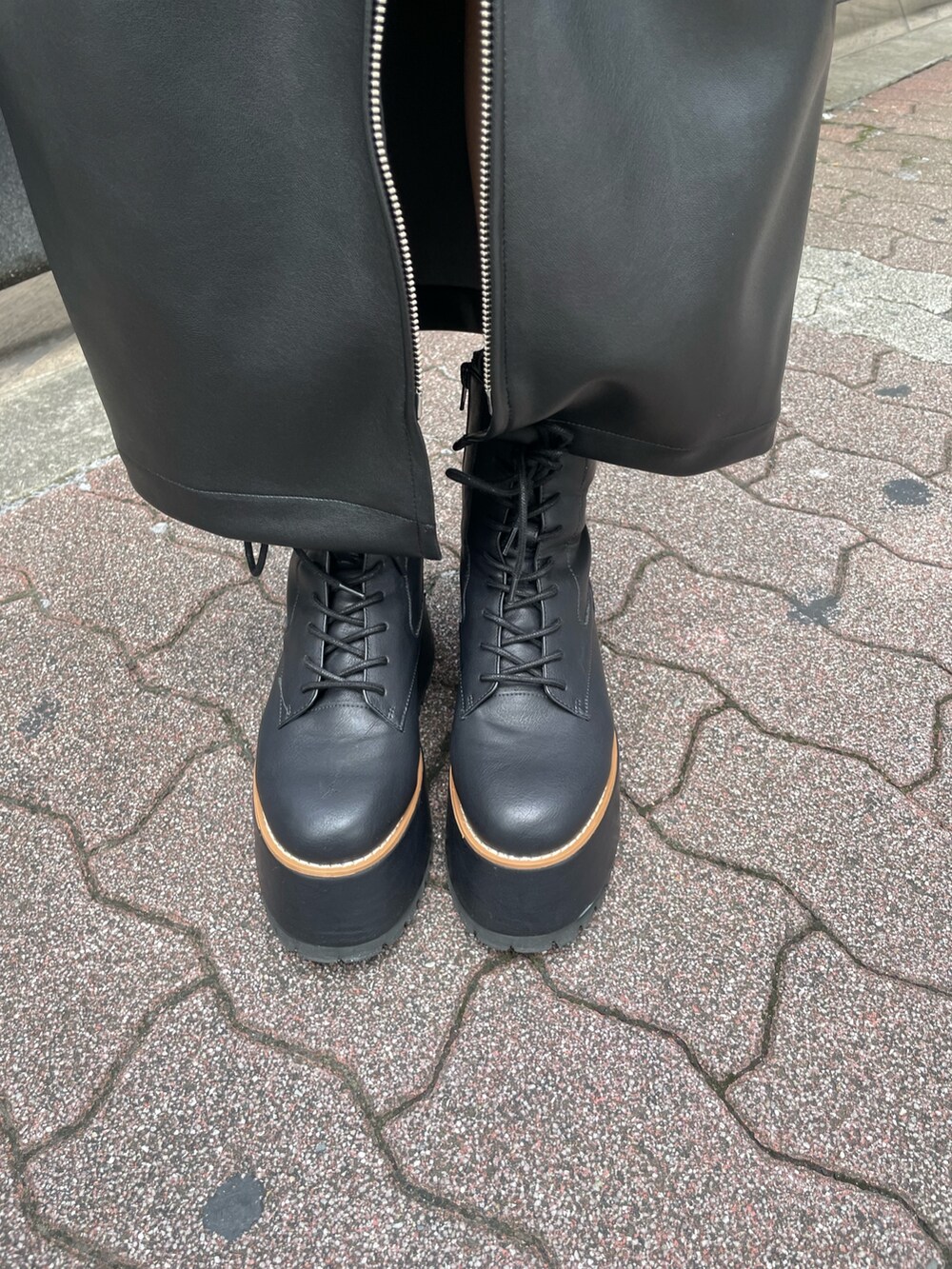 ブラック系のニット/セーター、ブラック系のスカート、ブラック系のブーツを着用したレディースの秋コーディネートの8枚目の写真