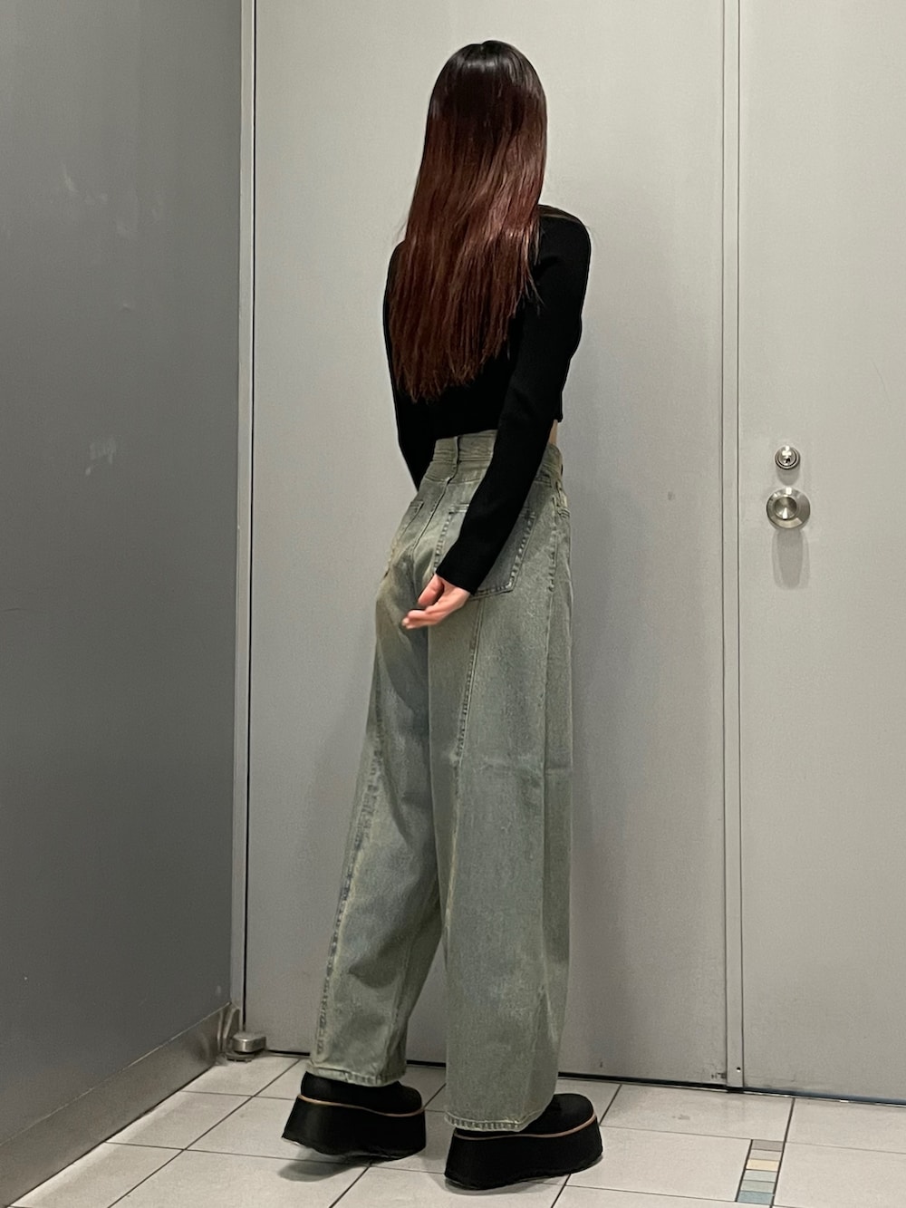 ブラック系のブーツ、ブルー系のデニムパンツ、ブラック系のニット/セーターを着用したレディースの冬コーディネートの3枚目の写真