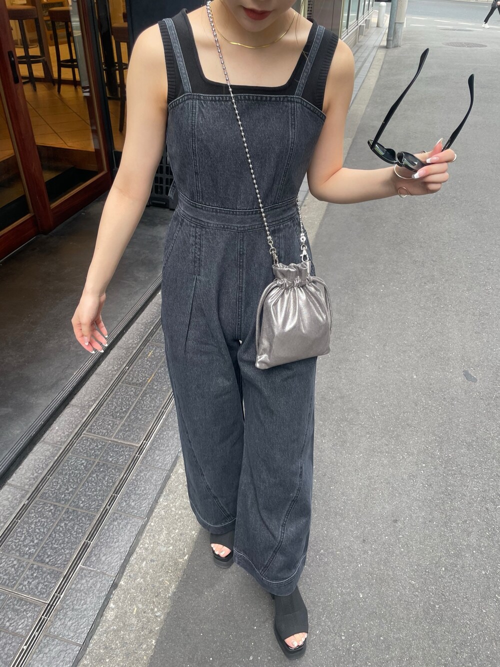 グレー系のショルダーバッグ、ブラック系のブーツ、ブラック系のニット/セーターを着用したレディースの春コーディネートの7枚目の写真