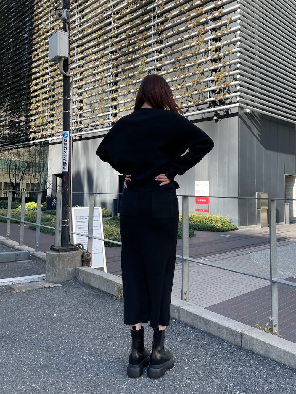 ブラック系のニット/セーター、ブラック系のスカート、ブラック系のブーツを着用したレディースの冬コーディネートの3枚目の写真