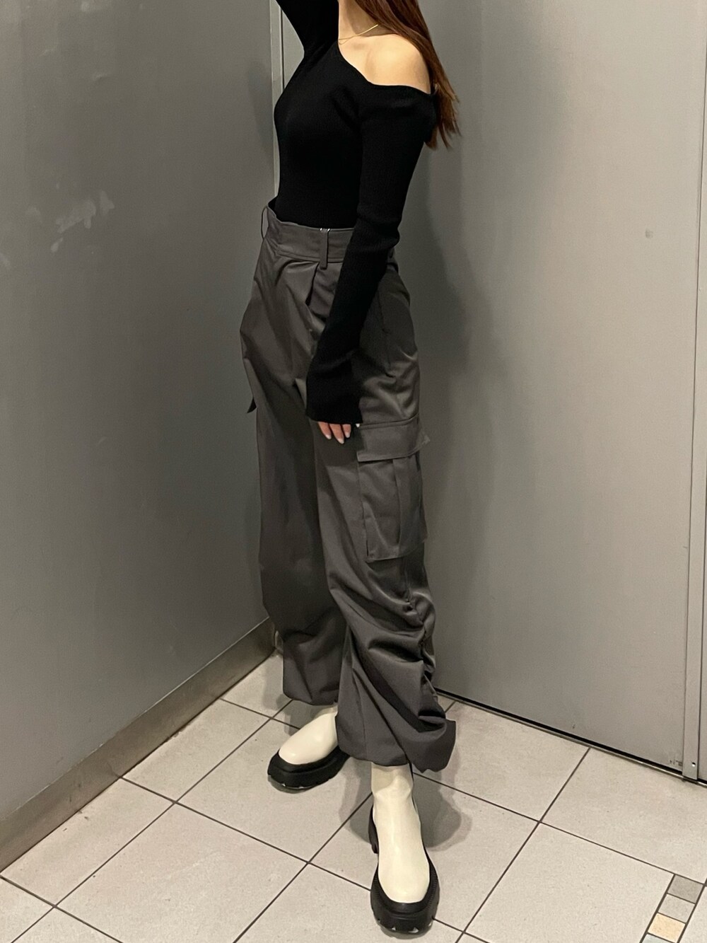 ブラック系のニット/セーター、グレー系のカーゴパンツ、ホワイト系のブーツを着用したレディースの冬コーディネートの3枚目の写真