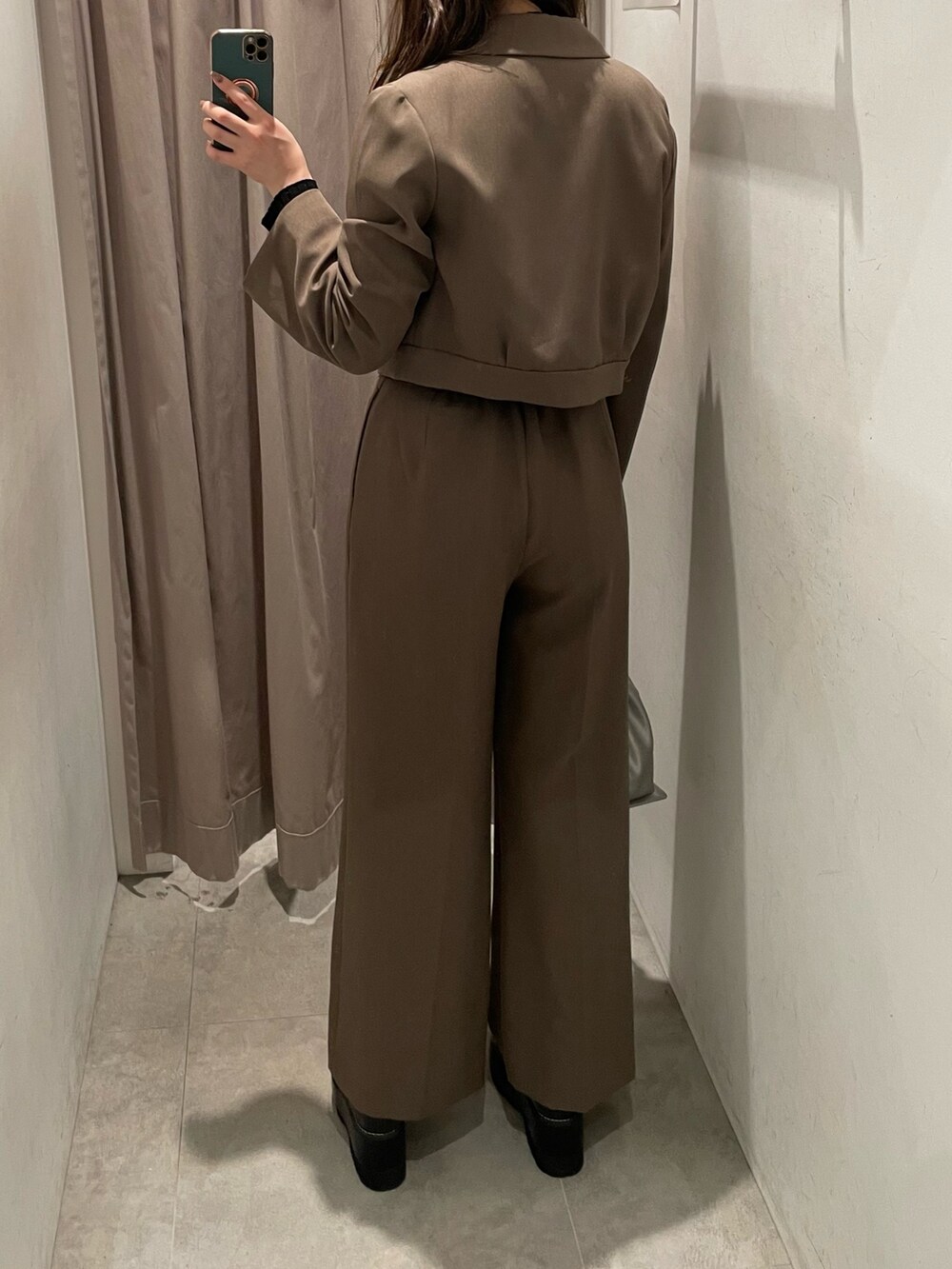 ブラウン系のテーラードジャケット、ブラック系のニット/セーター、シルバー系のハンドバッグを着用したレディースの春コーディネートの3枚目の写真