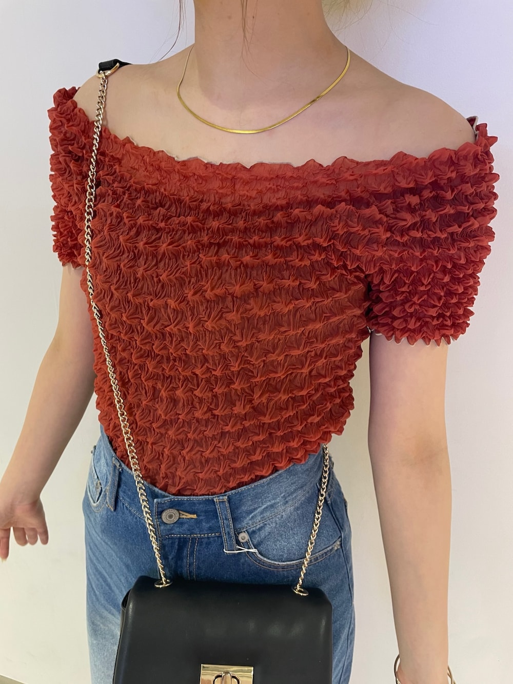 ブルー系のデニムパンツ、ブラック系のブーツ、レッド系のシャツ/ブラウスを着用したレディースの春コーディネートの5枚目の写真