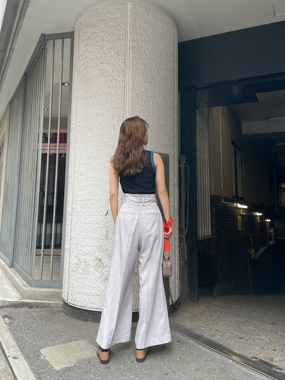 グレー系のニット/セーター、グレー系のその他パンツ、ブルー系のショルダーバッグを着用したレディースの夏コーディネートの3枚目の写真