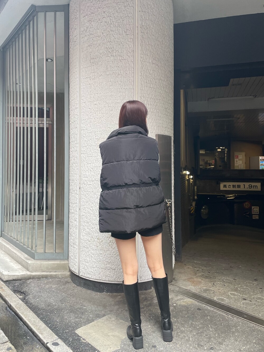 ブラック系のダウンベスト、ホワイト系のニット/セーター、ブラック系のその他パンツを着用したレディースの秋コーディネートの4枚目の写真