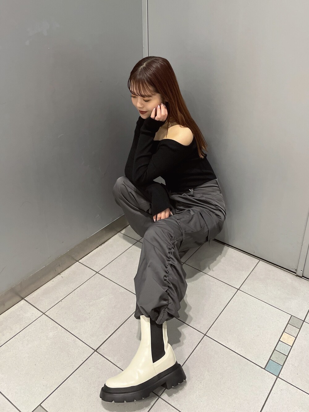 ブラック系のニット/セーター、グレー系のカーゴパンツ、ホワイト系のブーツを着用したレディースの冬コーディネートの5枚目の写真