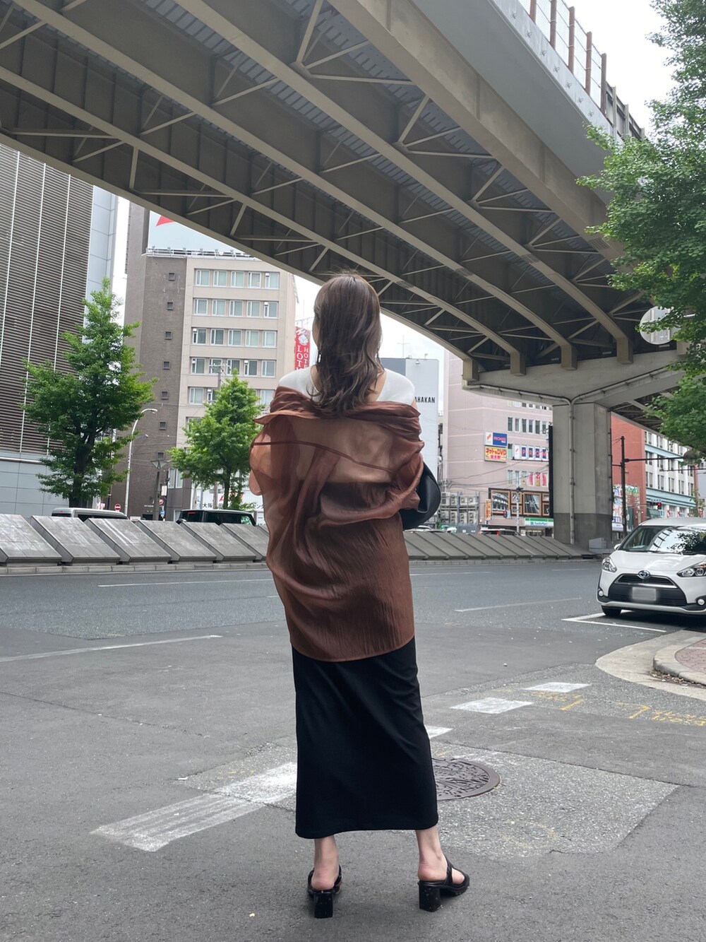 ブラック系のハンドバッグ、ブラック系のサンダル、ブラウン系のシャツ/ブラウスを着用したレディースの春コーディネートの3枚目の写真