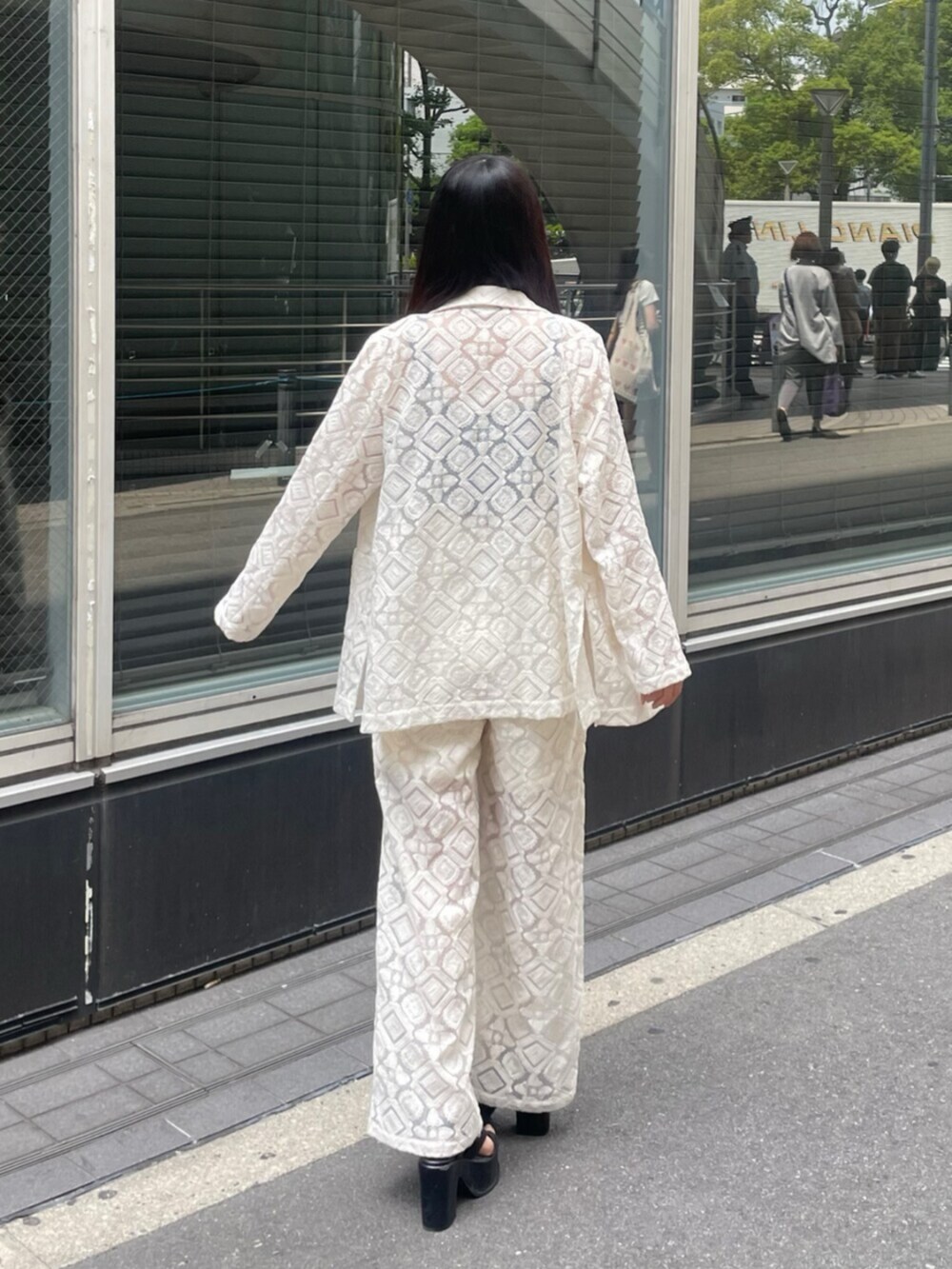 ブラック系のサンダル、ホワイト系のテーラードジャケット、ホワイト系のその他パンツを着用したレディースの春コーディネートの3枚目の写真