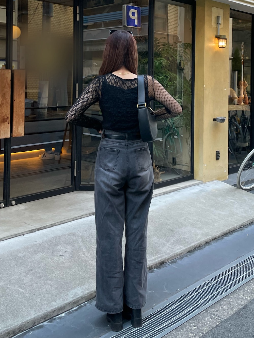 ブラック系のデニムパンツ、ブラック系のTシャツ/カットソー、ブラック系のブーツを着用したレディースの秋コーディネートの3枚目の写真