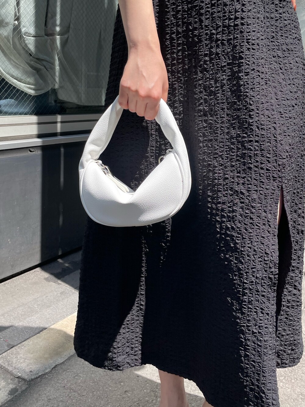 ホワイト系のハンドバッグ、ブラック系のサンダル、グリーン系のタンクトップを着用したレディースの春コーディネートの8枚目の写真