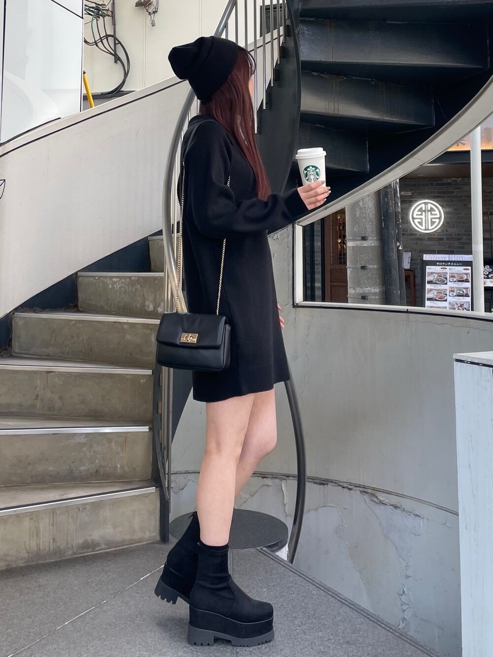 ブラック系のワンピース、ブラック系のブーツを着用したレディースの冬コーディネートの2枚目の写真