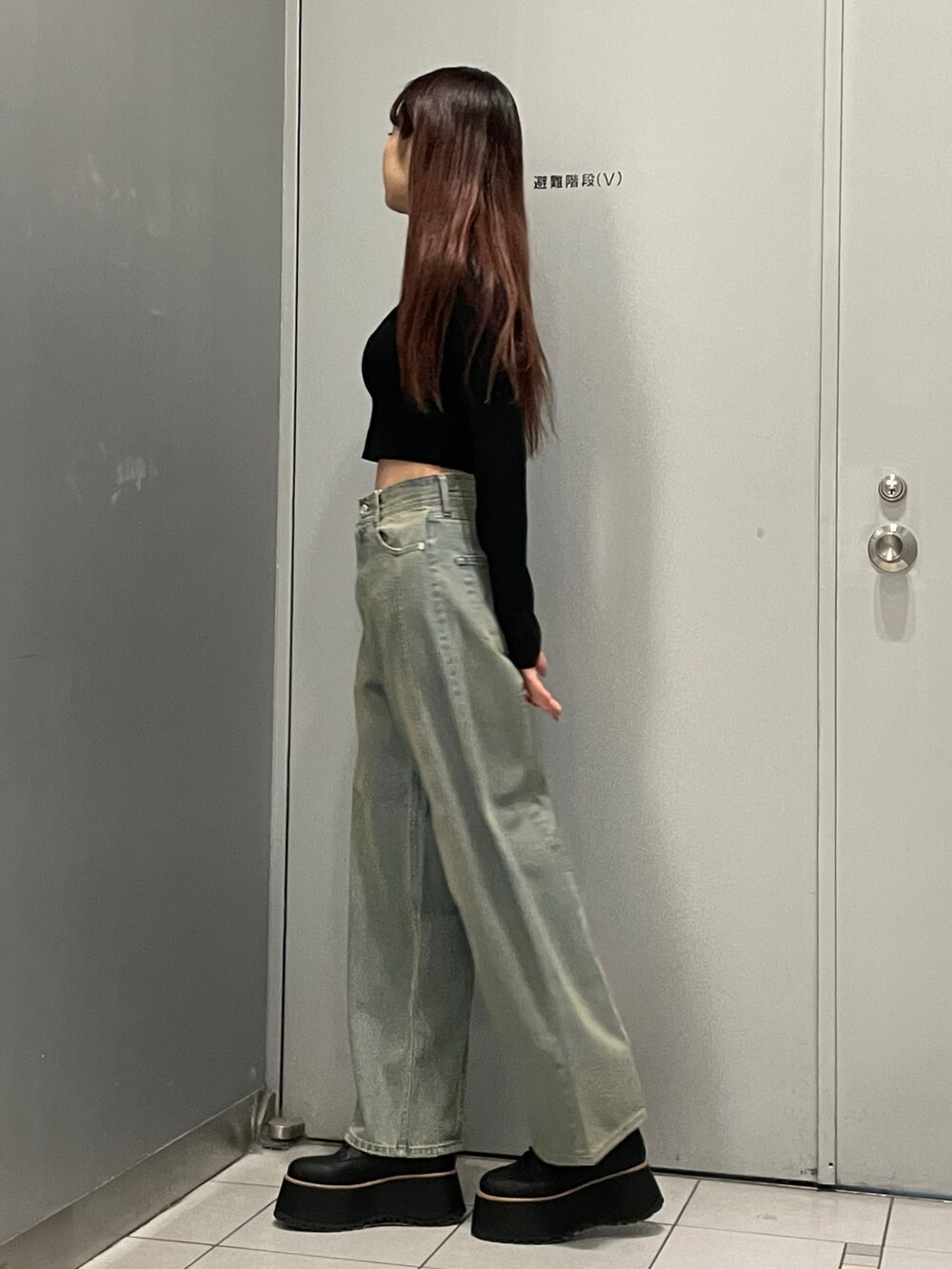 ブラック系のブーツ、ブルー系のデニムパンツ、ブラック系のニット/セーターを着用したレディースの冬コーディネートの2枚目の写真