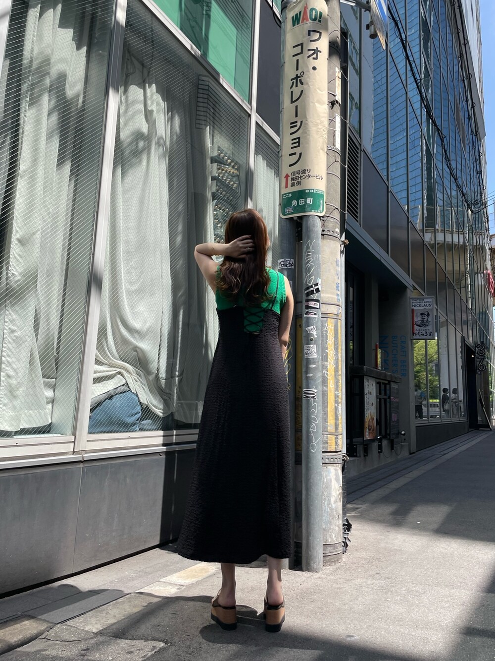 ホワイト系のハンドバッグ、ブラック系のサンダル、グリーン系のタンクトップを着用したレディースの春コーディネートの3枚目の写真