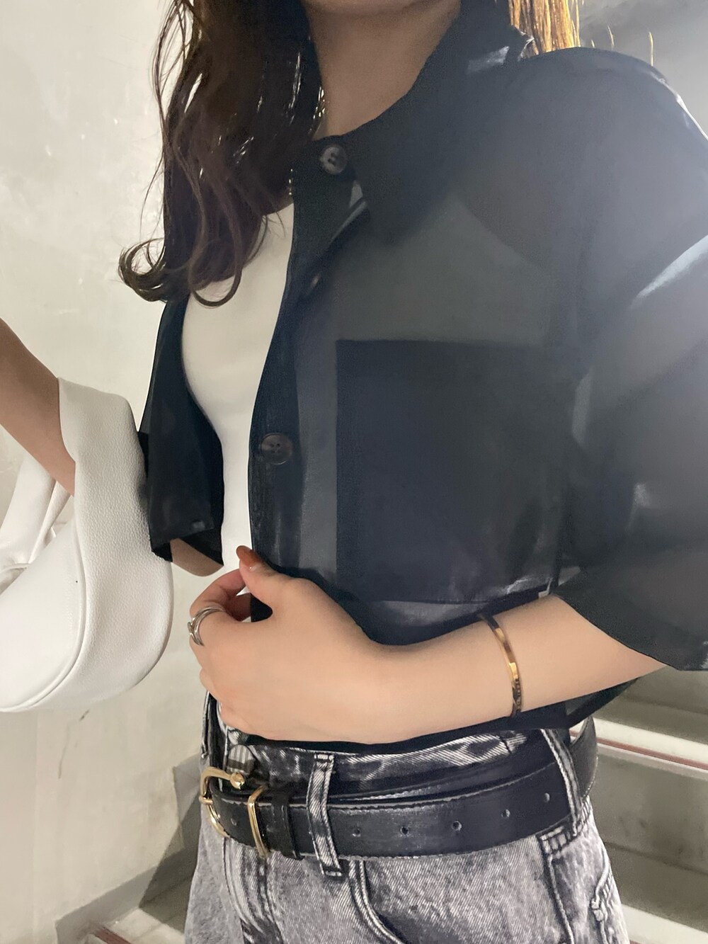 ホワイト系のTシャツ/カットソー、グレー系のデニムパンツ、ブラック系のサンダルを着用したレディースの春コーディネートの6枚目の写真