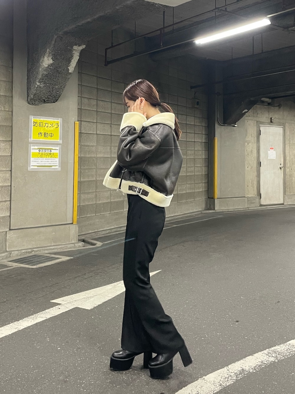 ブラック系のブーツ、ブラック系のスラックス、ブラック系のニット/セーターを着用したレディースの夏コーディネートの2枚目の写真