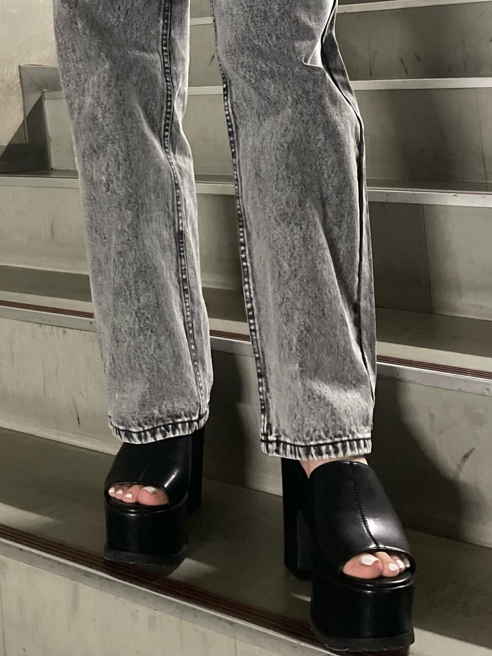 ホワイト系のTシャツ/カットソー、グレー系のデニムパンツ、ブラック系のサンダルを着用したレディースの春コーディネートの8枚目の写真