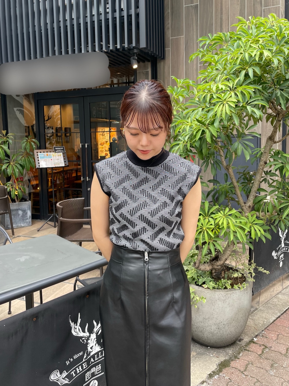 ブラック系のニット/セーター、ブラック系のスカート、ブラック系のブーツを着用したレディースの秋コーディネートの4枚目の写真