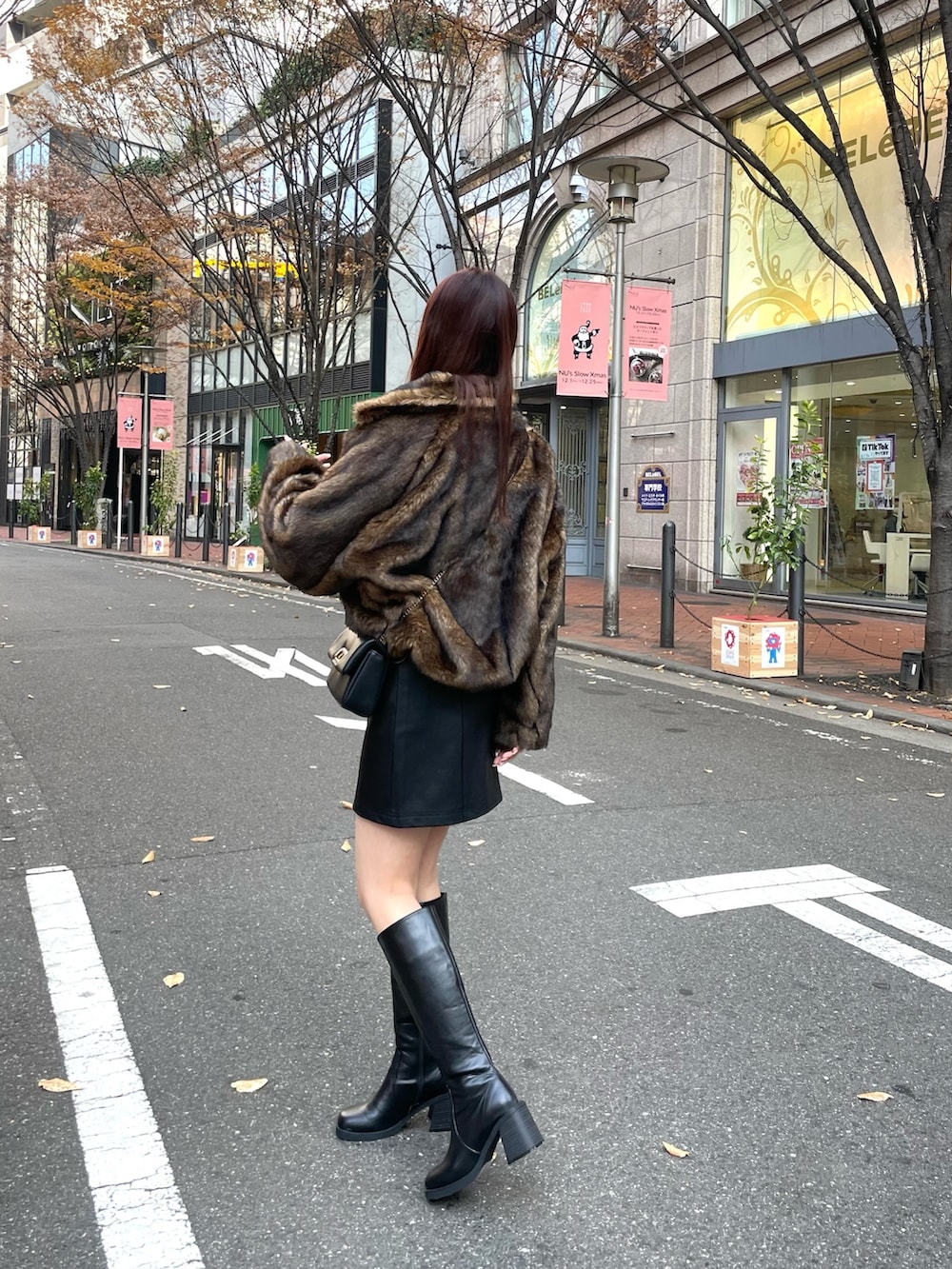 ブラック系のブーツ、ブラック系のスカート、レッド系のニット/セーターを着用したレディースの冬コーディネートの4枚目の写真